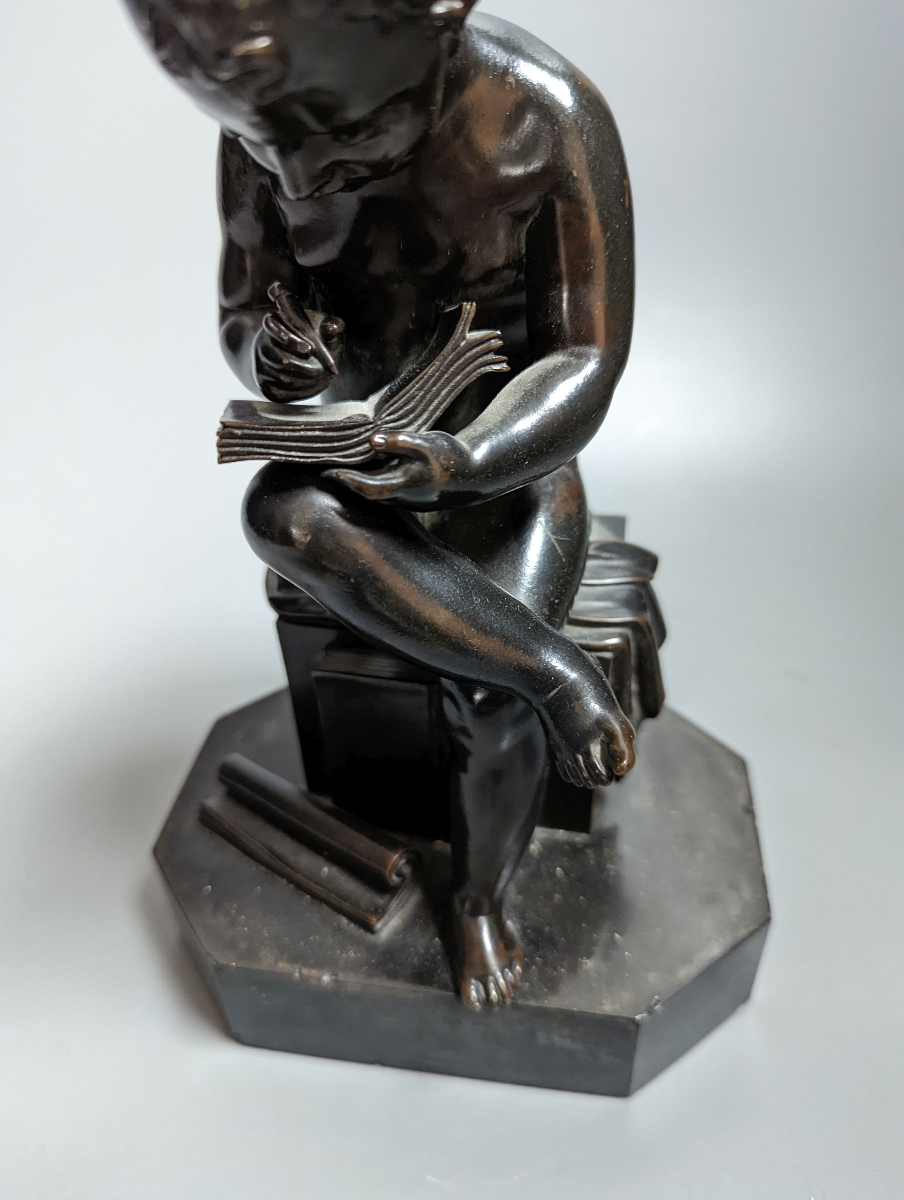 A pair of late 19th century bronze figures of seated putti plotting and writing notes, 26cm